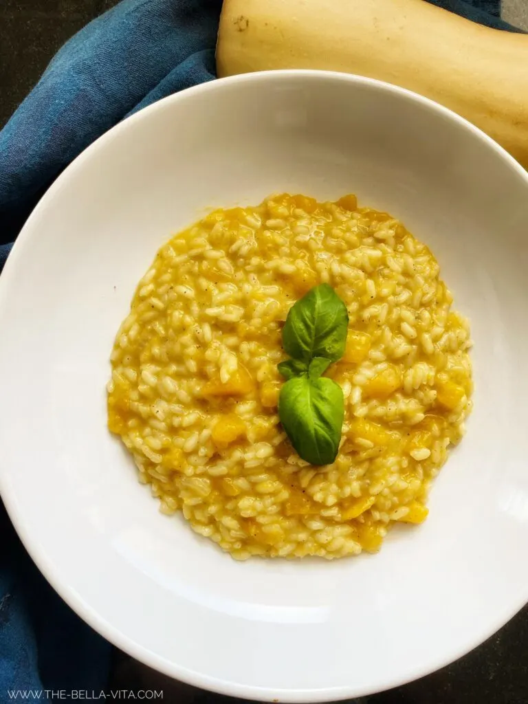 Creamy & Easy Pumpkin Risotto in a plate garnished with  basil 