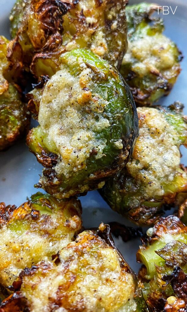 Close-up of crispy smashed brussel sprouts with golden-brown edges and a parmesan crust, showcasing the delicious texture of this trending recipe.