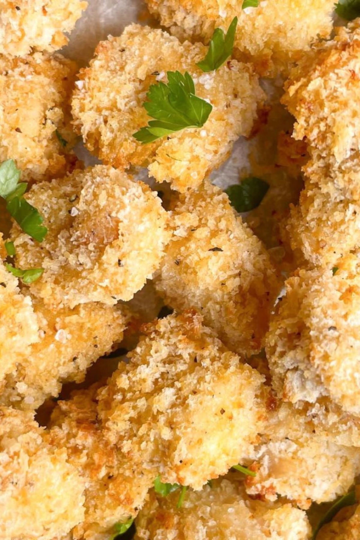 Golden, crispy baked chicken nuggets, garnished with parsley. A quick and delicious 30 minute meal, perfect for busy weeknights.