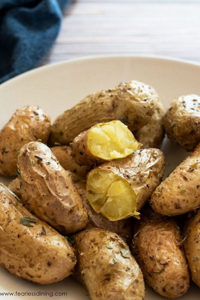 Roasted fingerling potatoes with herbs, one potato cut in half