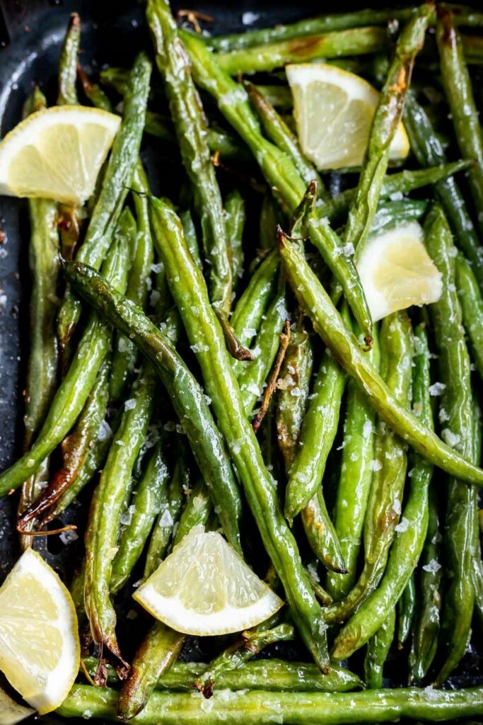 Roasted green beans with lemon wedges and sea salt