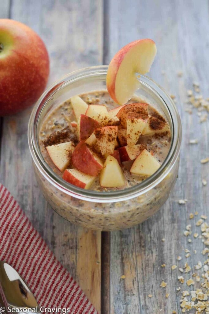 Apple Pie Overnight Oats Overnight oats recipe in a glass jar, topped with diced apples and cinnamon.