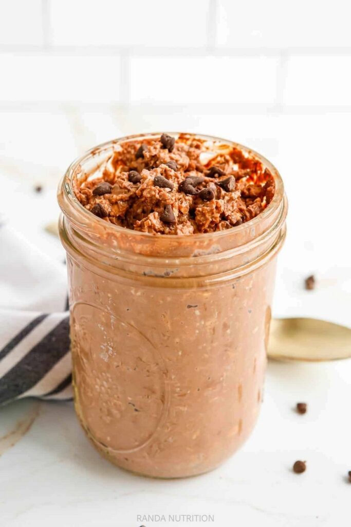 Brownie Batter Overnight Oats Chocolate overnight oats in a glass jar, topped with chocolate chips.