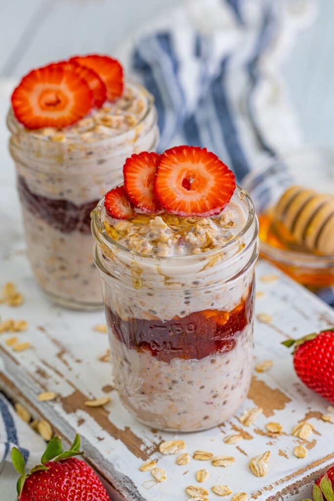 Strawberry Overnight Oats Plus How Long Do They Last Overnight oats recipes: Two mason jars filled with strawberry overnight oats, topped with sliced strawberries and honey.
